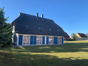 a blue and white house with a gambrel roof at Zur Fischerwurt 8 in Balm