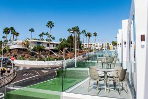 een balkon met een tafel en stoelen en palmbomen bij Amor a mar whale in Puerto del Carmen