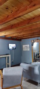 ein Wohnzimmer mit 2 Stühlen und einem Flachbild-TV in der Unterkunft Villa la Angostura in Villa La Angostura