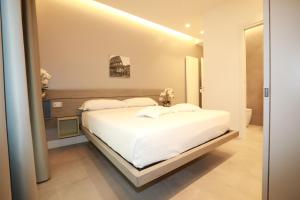 een slaapkamer met een wit bed en een badkamer bij Unique Luxury Stay in Rome