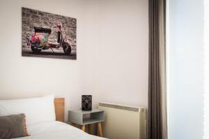 a bedroom with a bed with a scooter painting on the wall at 2 bed spacious, light & quiet flat, free parking in Heaton