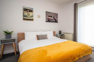 um quarto com uma cama grande e um cobertor amarelo em 2 bed spacious, light & quiet flat, free parking em Heaton