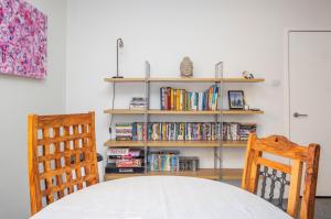 2 bed spacious, light & quiet flat, free parking في Heaton: طاولة مع كرسيين و رف للكتب
