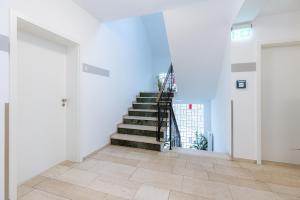 雷德斯塔德的住宿－Hotel Villa Positano，白色墙壁的房间内的楼梯