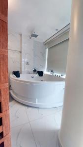 a large white bath tub in a white bathroom at HOTEL REAL PLAZA in Cajamarca