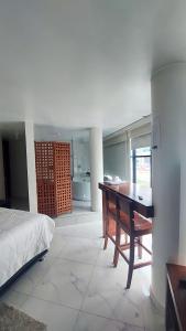 a bedroom with a desk and a bed and a kitchen at HOTEL REAL PLAZA in Cajamarca