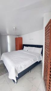 a bedroom with a large bed with white sheets at HOTEL REAL PLAZA in Cajamarca