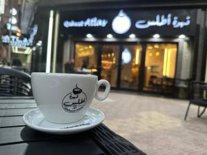 una taza de café sentada en una mesa frente a una tienda en Atlas International Hotels en El Cairo