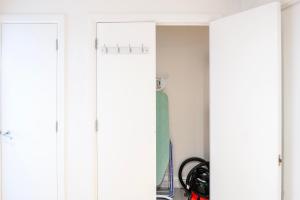 a closet with white walls and two doors at The Bright Flat in Whitechapel in London
