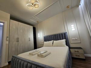 um quarto com uma cama grande com duas toalhas em Miku Apartment-Cozy 1BD Apartment at Komuna e Parisit em Tirana