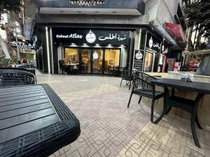 Atlas International Hotels في القاهرة: مطعم فيه طاولات وكراسي امام محل