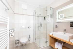 a bathroom with a shower and a toilet and a sink at Hotel Landgasthof Gappen in Kramsach