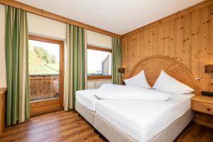 a bedroom with a white bed and a window at Hotel Landgasthof Gappen in Kramsach