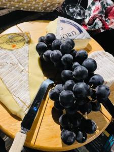un montón de uvas en una tabla de cortar con un cuchillo en Maison Des Glycines, en Droux
