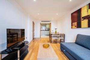 a living room with a blue couch and a table at Modern Paddington Station 2 Bedroom Apartment in London