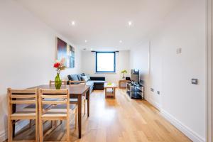 a dining room and living room with a table and chairs at Modern Paddington Station 2 Bedroom Apartment in London