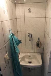 W łazience znajduje się umywalka i zielony ręcznik. w obiekcie Schusterhof w mieście Marquartstein