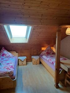 a bedroom with two beds in a wooden cabin at Schusterhof in Marquartstein