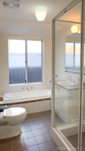 a bathroom with a shower and a toilet and a sink at Fremantle High Street Retreat in Fremantle