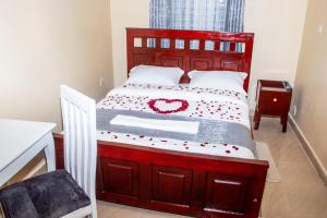 a bedroom with a bed with a red heart on it at Lavish Haven Home in Bungoma