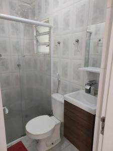 y baño con aseo, lavabo y ducha. en Flat Pé de Mamão, en Campinas