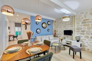 a dining room and living room with a table and chairs at Residence Tour Eiffel by Studio prestige in Paris