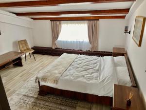 Schlafzimmer mit einem Bett, einem Schreibtisch und einem Fenster in der Unterkunft Parc Vatra Dornei 1 - Family, couples & groups in Vatra Dornei