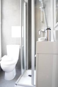 ein Bad mit einem WC und einer Glasdusche in der Unterkunft Paris, Opéra 2D...pour un séjour magique in Paris