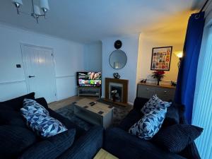 a living room with a couch and a tv at Station house in Ramsgate