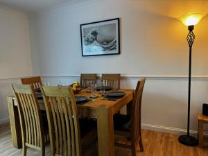 a dining room table with chairs and a lamp at Station house in Ramsgate