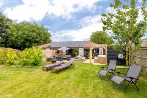 a backyard with a picnic table and chairs and a house at Stylish Getaway Vast Courtyard Hot Tub 