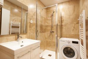a bathroom with a washing machine and a washer at Paul Riquet 1609 City Center Residences in Béziers