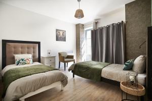 een slaapkamer met een bed, een stoel en een raam bij Paul Riquet 1609 City Center Residences in Béziers