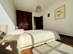 um quarto branco com uma cama e uma mesa em Onda Beach House em Cortegaça