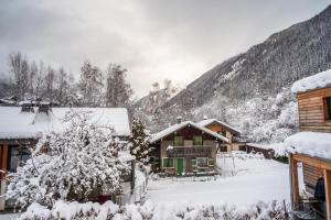 une cabane en rondins avec de la neige sur le toit dans l'établissement Chalet Sia - Contemporain - Sauna prive, à Chamonix-Mont-Blanc