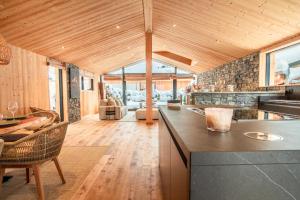 une cuisine ouverte avec un comptoir et un salon dans l'établissement Chalet Sia - Contemporain - Sauna prive, à Chamonix-Mont-Blanc