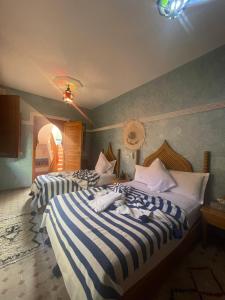 A bed or beds in a room at Riad Jenan Adam
