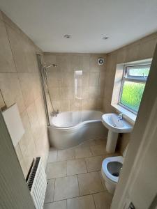 a bathroom with a tub and a toilet and a sink at Canvas House in Carlisle