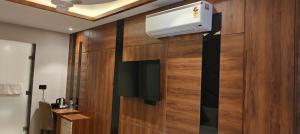 La salle de bains est pourvue de la climatisation sur un mur en bois. dans l'établissement HOTEL GOLDEN PEACOCK, à Haridwar