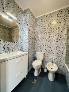 uma casa de banho com um WC branco e um lavatório. em Onda Beach House em Cortegaça