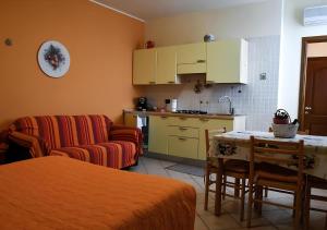 a kitchen and a living room with a couch and a table at Gli Angeli Agriturismo - Zia Rosa in Cisano sul Neva