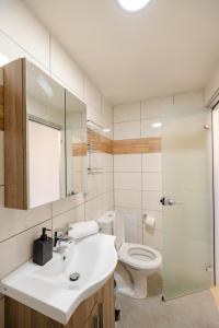 a bathroom with a sink and a toilet at Blue Riviera villas & suites - Rodos in Koskinou