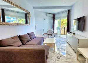 uma sala de estar com um sofá e uma televisão em SKOL 424 Stunning One-bedroom apartment with sea views em Marbella