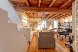 Milan Royal Suites - Castello في ميلانو: غرفة معيشة بسقوف خشبية وغرفة طعام