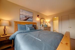 a bedroom with a large blue bed with a wooden headboard at Centrally Located Sparks Condo with Private Patio! in Sparks