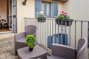 einen Balkon mit Stühlen und Pflanzen auf einem Geländer in der Unterkunft Milan Royal Suites - Castello in Mailand
