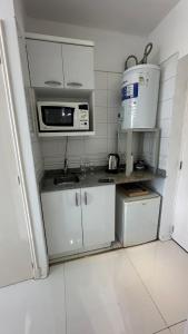 una piccola cucina con armadietti bianchi e forno a microonde di Apartamento Millennium inn a Mendoza