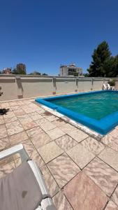una piscina su un patio con una sedia accanto di Apartamento Millennium inn a Mendoza