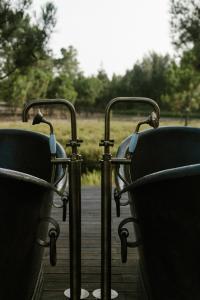 2 sillas en la parte superior de una terraza de madera en Craveiral Farmhouse by Belong Staying & Feeling, en São Teotónio