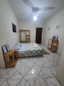 1 dormitorio con 1 cama y suelo de baldosa en BC Paradise Hostel & Suítes, en Balneário Camboriú